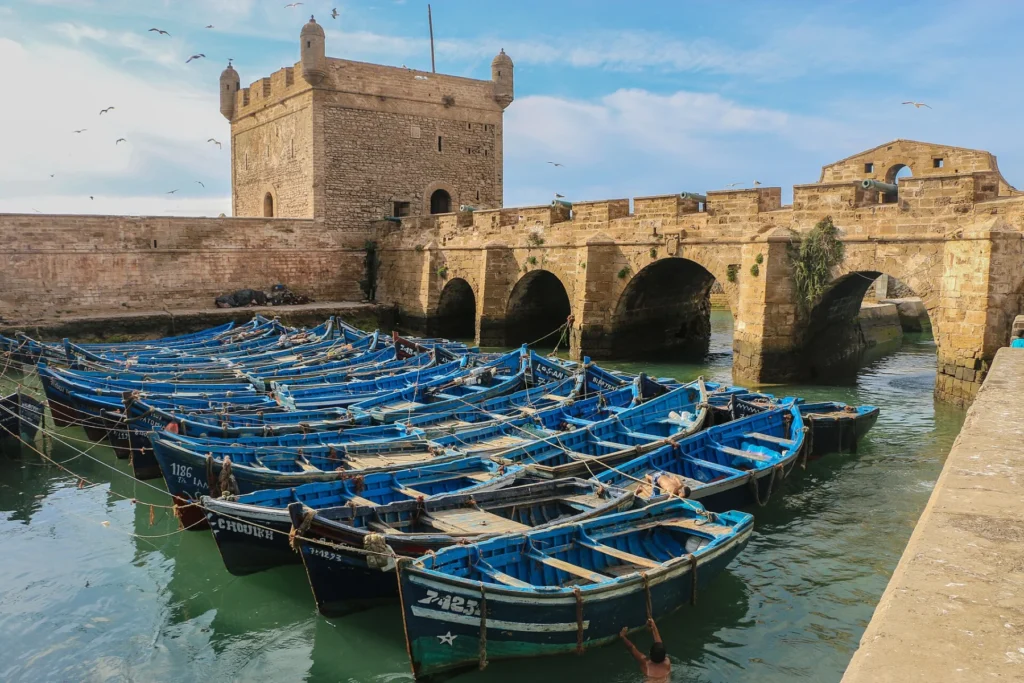 The harbour bastion of Essaouira with blue fishing boats moored below